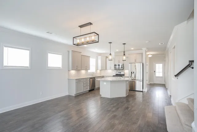 a large kitchen with a lot of counter space and wooden floor