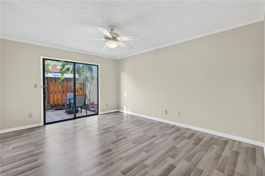 1414 Park Shore Circle, Unit 2 Fort Myers, FL 33901 - Photo 16 of 35 an empty room with wooden floor fan and windows