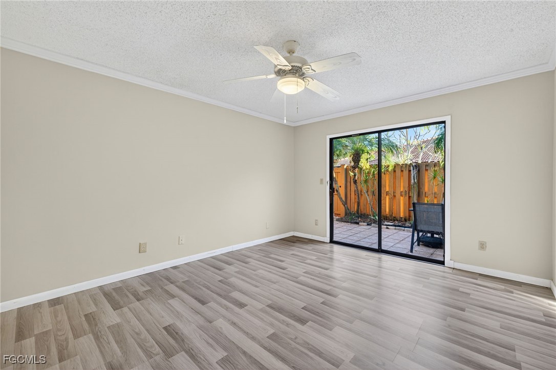 1414 Park Shore Circle, Unit 2 Fort Myers, FL 33901 - Photo 18 of 35 an empty room with wooden floor fan and windows