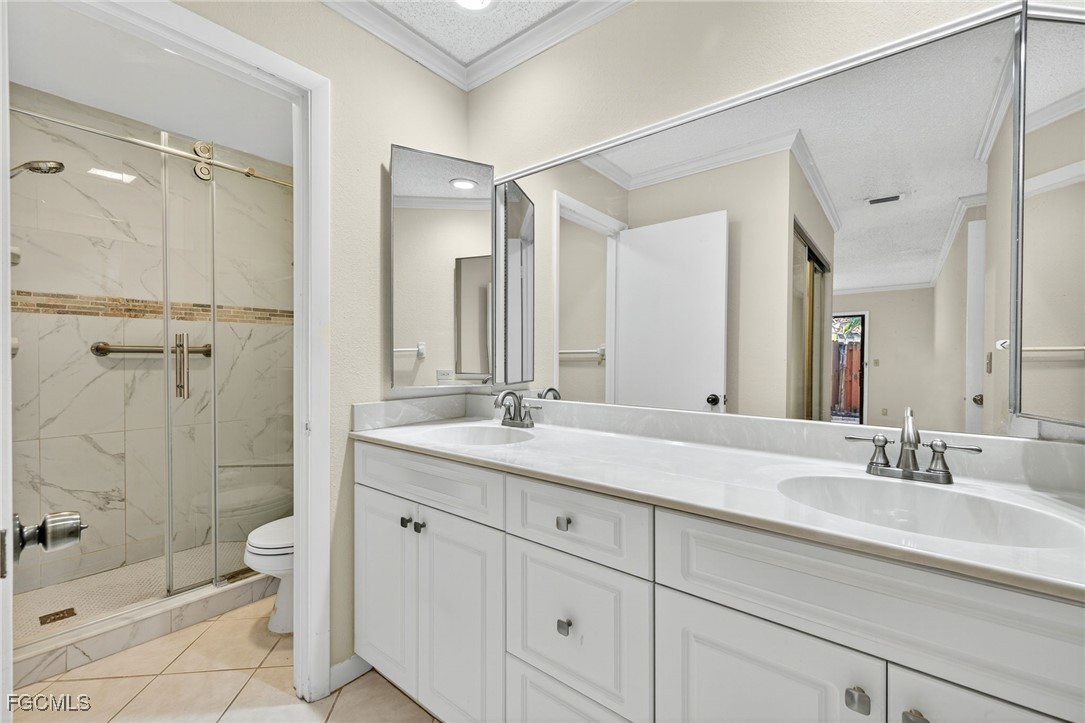 1414 Park Shore Circle, Unit 2 Fort Myers, FL 33901 - Photo 19 of 35 a bathroom with a double vanity sink toilet mirror and shower