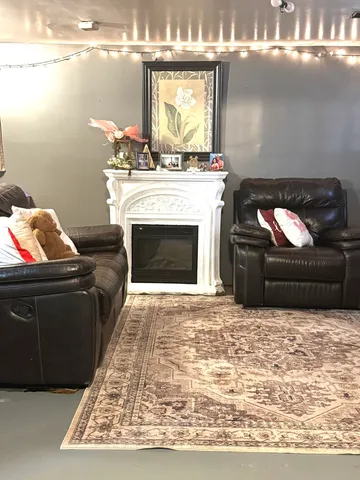 a living room with furniture fireplace and kitchen view