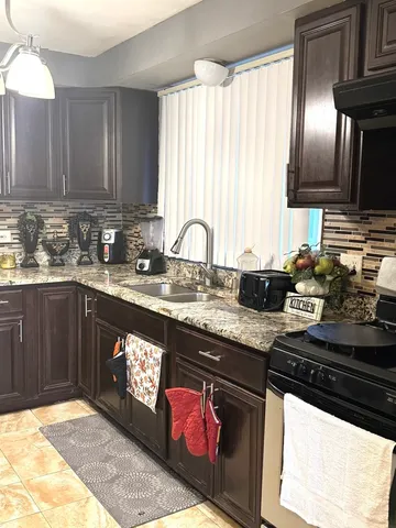 a kitchen with stainless steel appliances granite countertop a stove a sink and a microwave