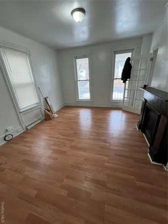 a view of a livingroom with wooden floor and a fireplace