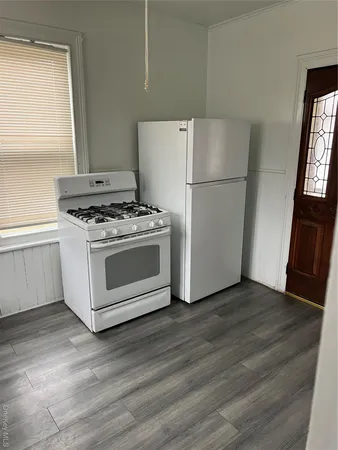 a white stove top oven sitting inside of a kitchen