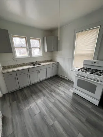 a kitchen with granite countertop a stove and a sink