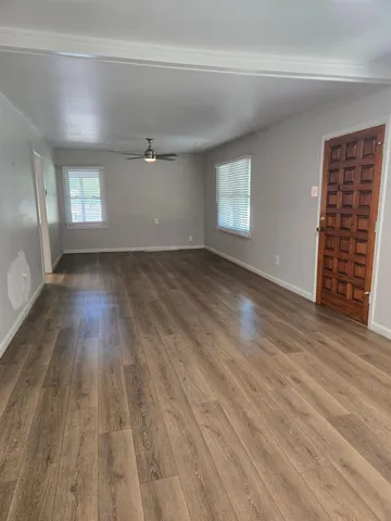 wooden floor in an empty room with a window