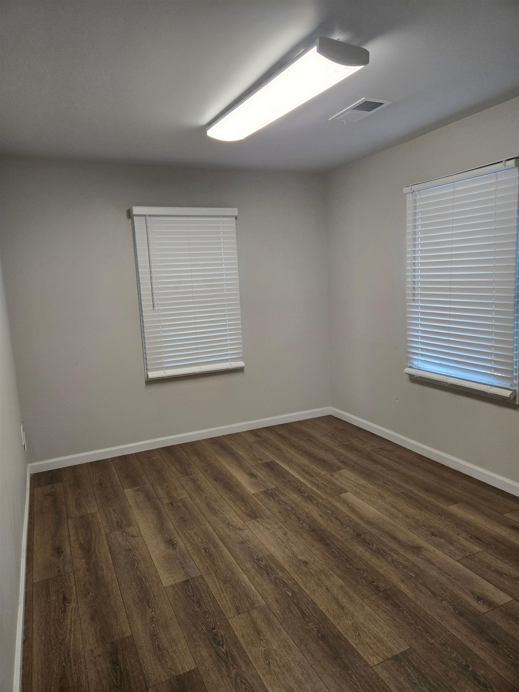 6871 Raleigh Lagrange Road Memphis, TN 38134 - Photo 6 of 8 an empty room with wooden floor and windows