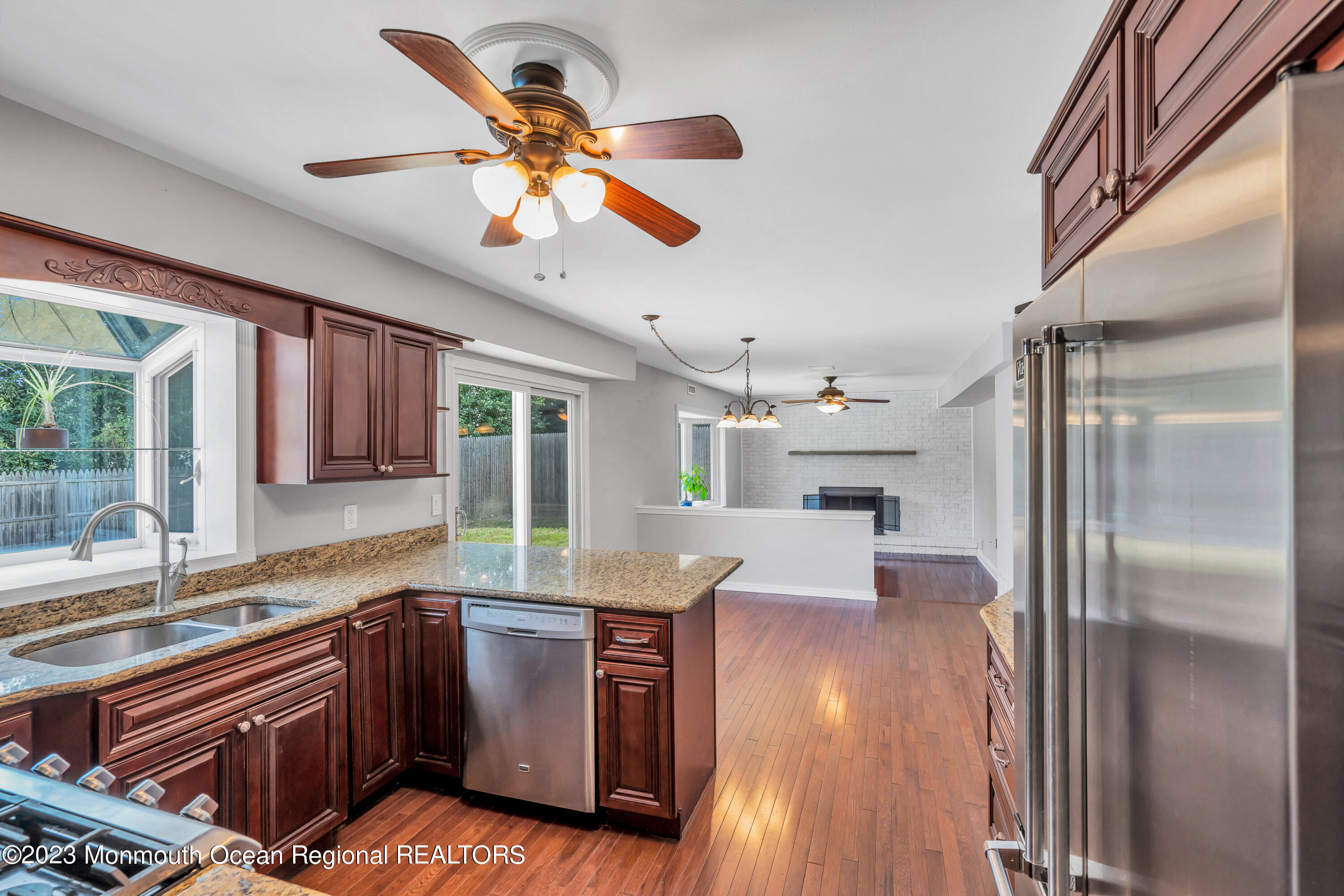 19 Poplar Street Howell, NJ 07731 - Photo 20 of 62 a kitchen with granite countertop a refrigerator a sink dishwasher a stove and a dining table with wooden floor