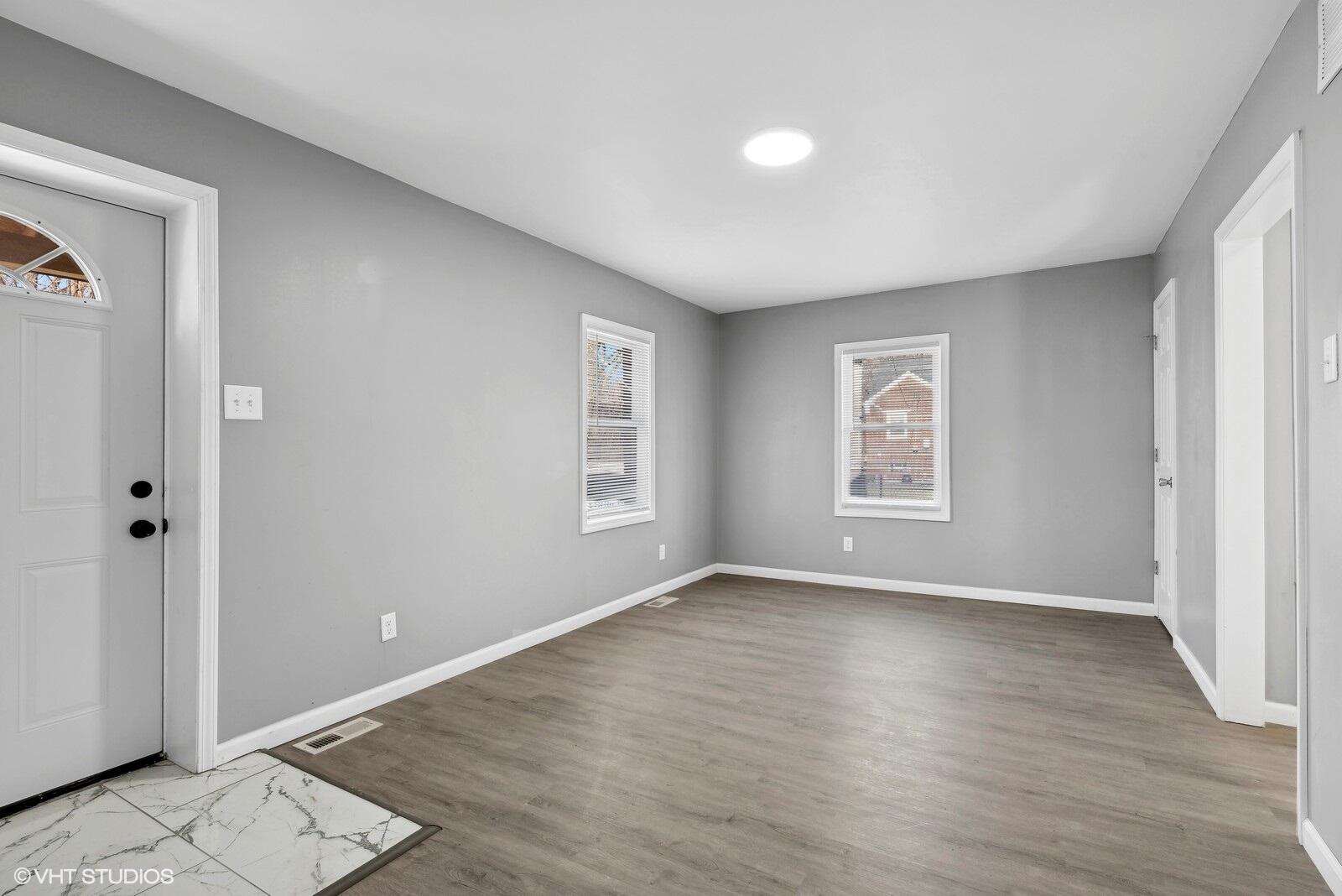 1025 Wallace Street Gary, IN 46404 - Photo 2 of 19 an empty room with wooden floor and windows