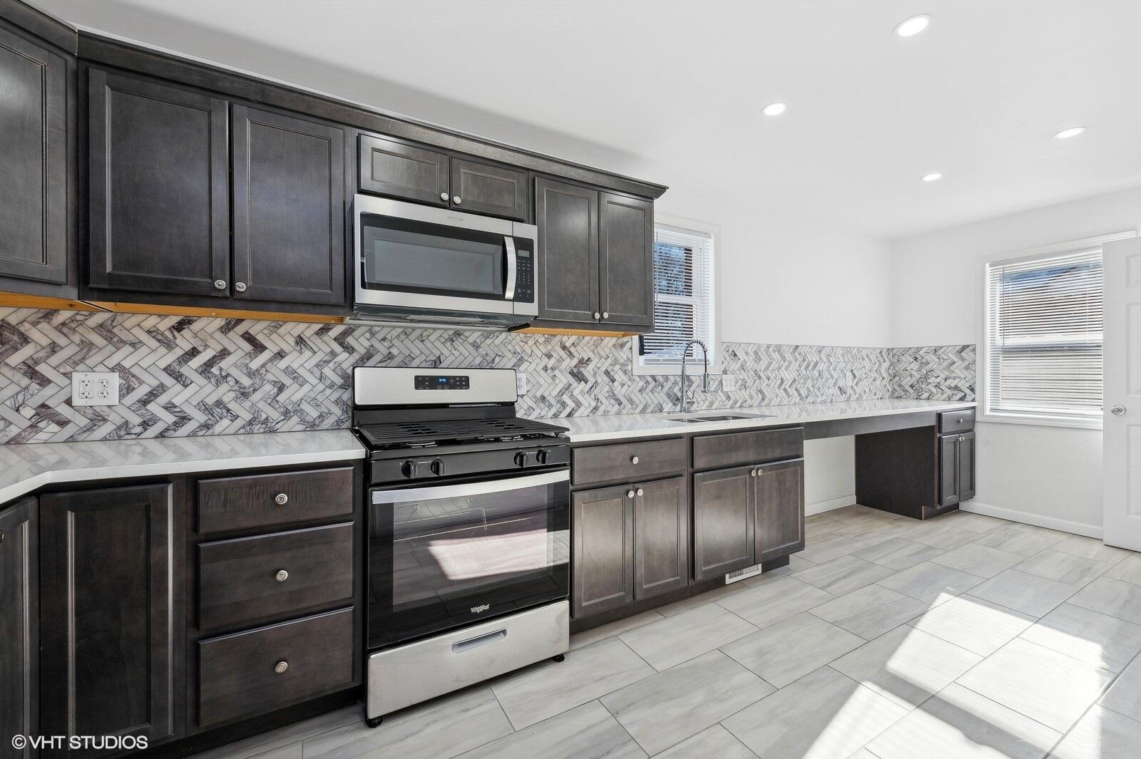 1025 Wallace Street Gary, IN 46404 - Photo 4 of 19 a kitchen with stainless steel appliances granite countertop a stove microwave and cabinets
