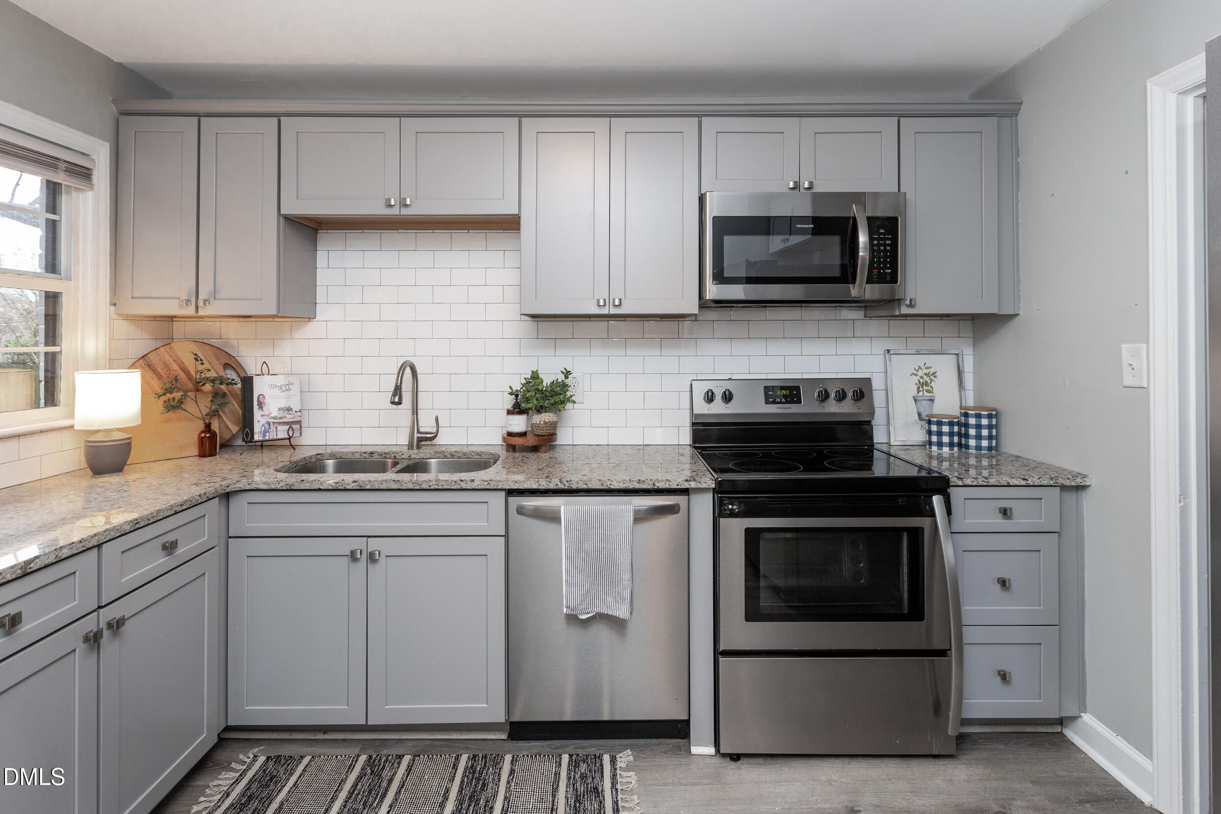 1206 Downing Road Raleigh, NC 27610 - Photo 3 of 13 a kitchen with white cabinets and stainless steel appliances