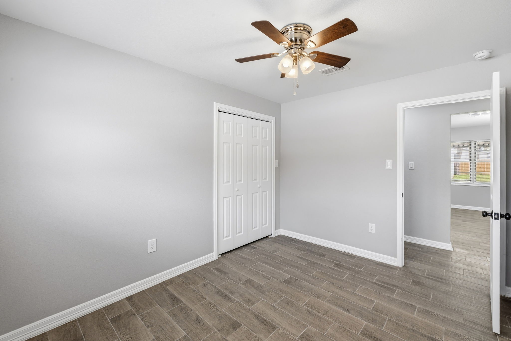 202 Massey Tompkins Road Baytown, TX 77521 - Photo 33 of 47 an empty room with wooden floor and a ceiling fan