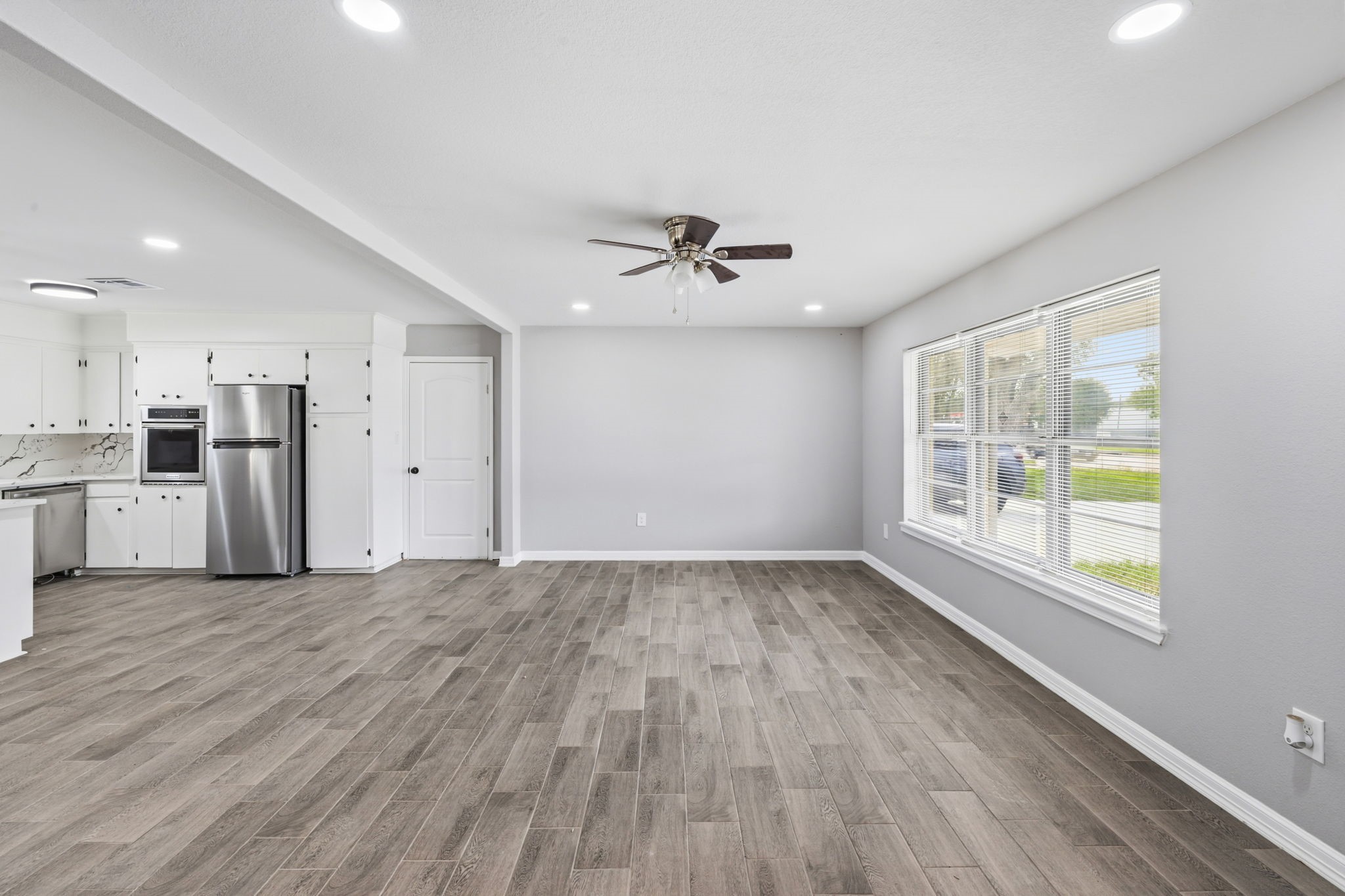 202 Massey Tompkins Road Baytown, TX 77521 - Photo 7 of 47 a view of an empty room with a window and wooden floor