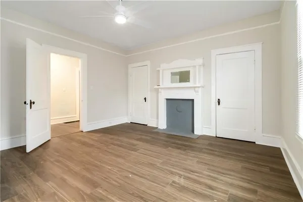 a view of empty room with wooden floor and fireplace
