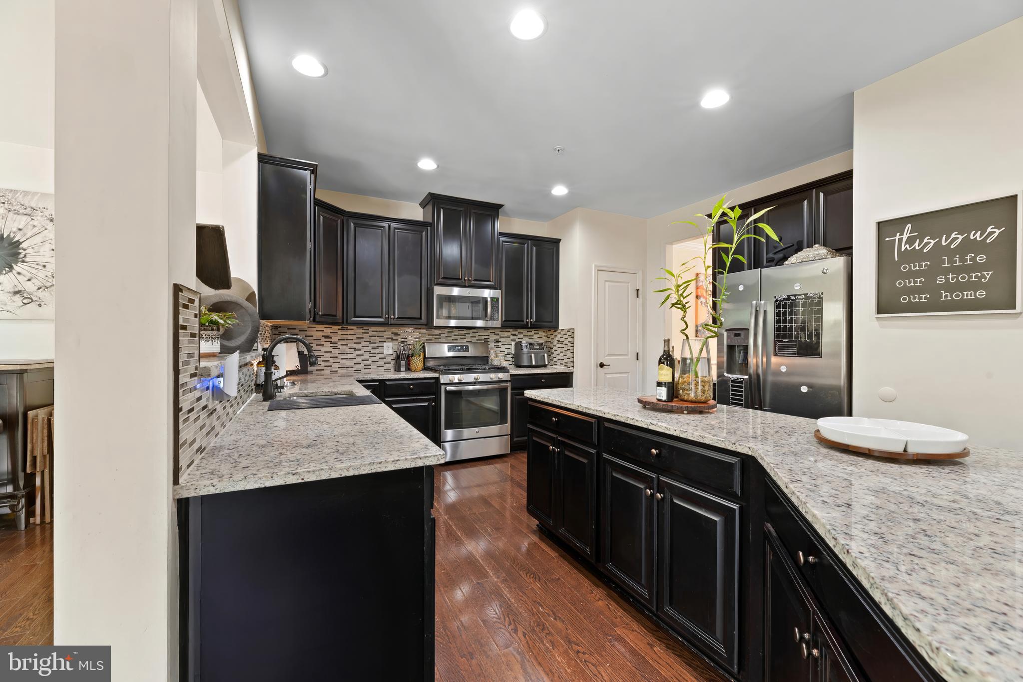 17857 Sugarberry Road Dumfries, VA 22026 - Photo 3 of 53 a kitchen with stainless steel appliances granite countertop sink stove refrigerator and cabinets