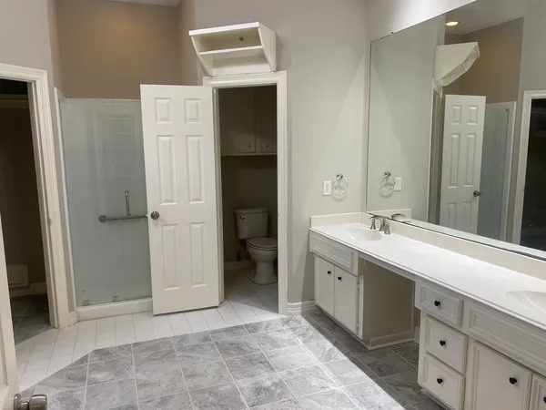 a spacious bathroom with a shower sink and mirror