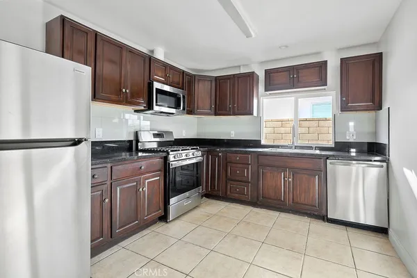 a kitchen with stainless steel appliances granite countertop a refrigerator stove a sink and dishwasher