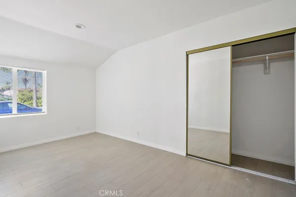 an empty room with windows and closet