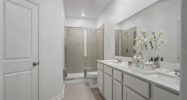a bathroom with a double vanity sink toilet and shower