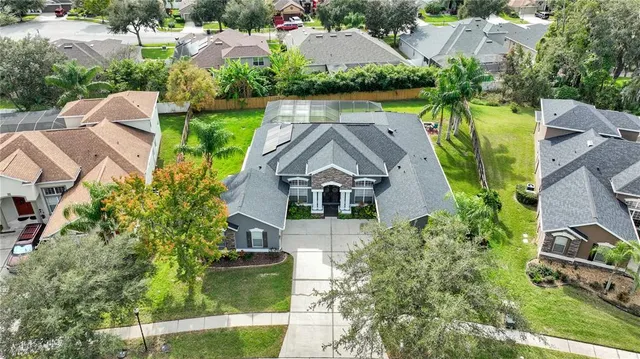 an aerial view of a house with a yard and large trees