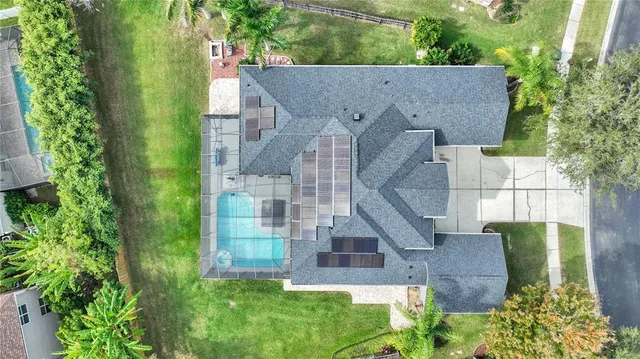 an aerial view of a house with a yard and lake view