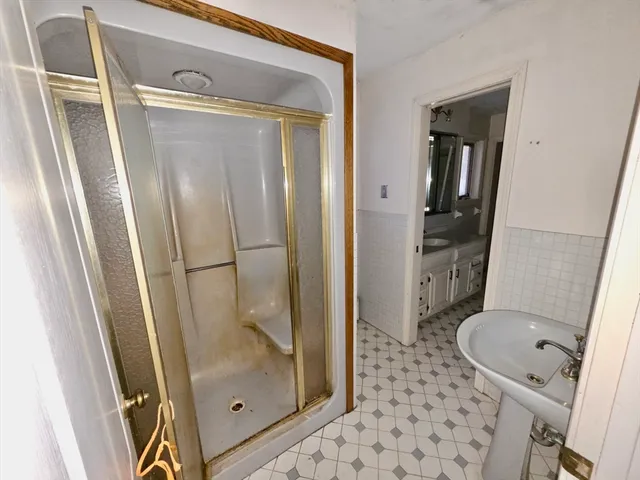 a bathroom with a glass door shower and a toilet