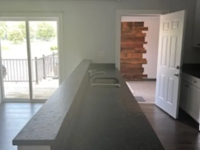 a kitchen with granite countertop a sink and a stove top oven