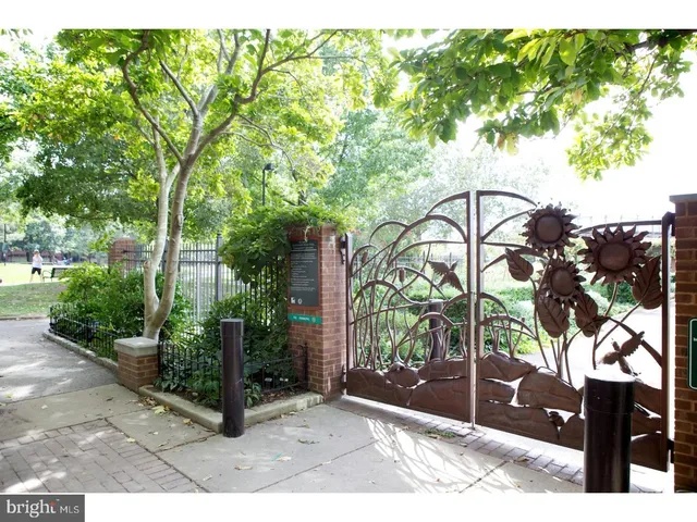 a front view of a multi story residential apartment building with yard and bench