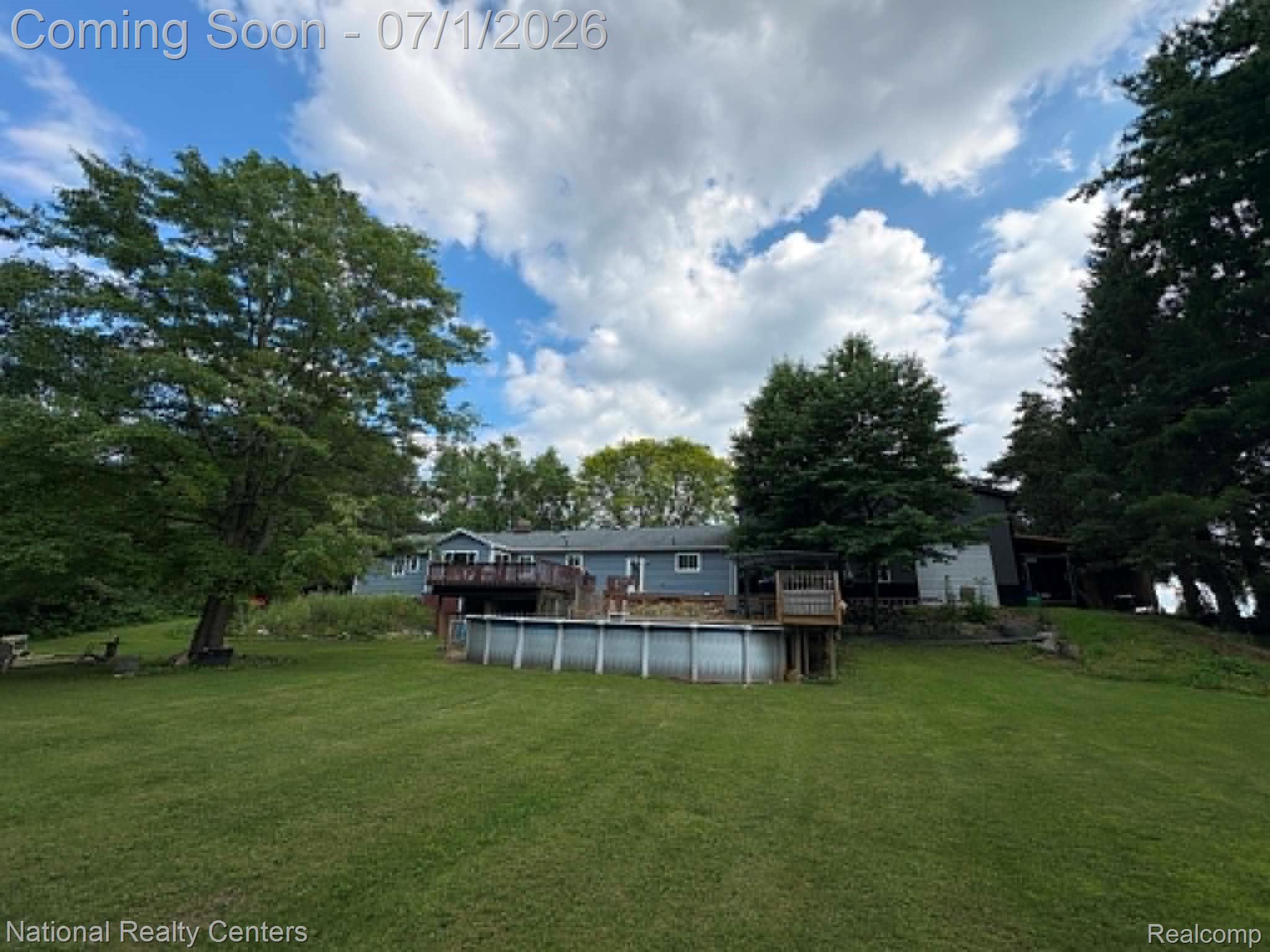 1330 Brauer Road Oxford, MI 48371 - Photo 7 of 54 Expansive green lawn with mature trees and an above-ground pool