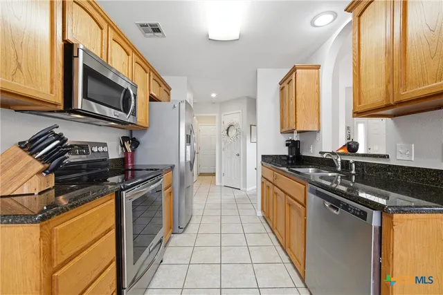 a kitchen with stainless steel appliances granite countertop a stove and a sink