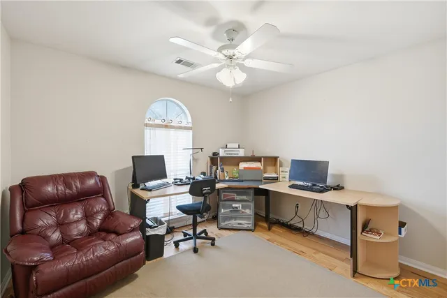 a workspace with furniture and a ceiling fan