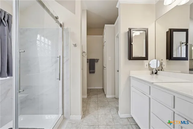 a bathroom with a double vanity sink mirror and shower