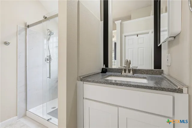a bathroom with a granite countertop sink and a mirror