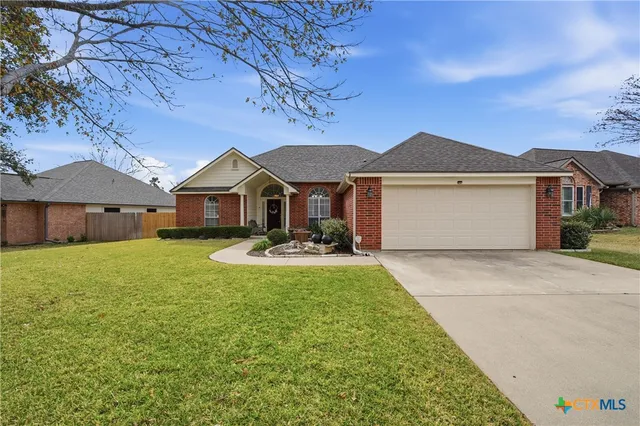 a front view of a house with yard patio and green space