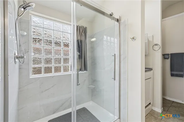 a bathroom with a glass shower door
