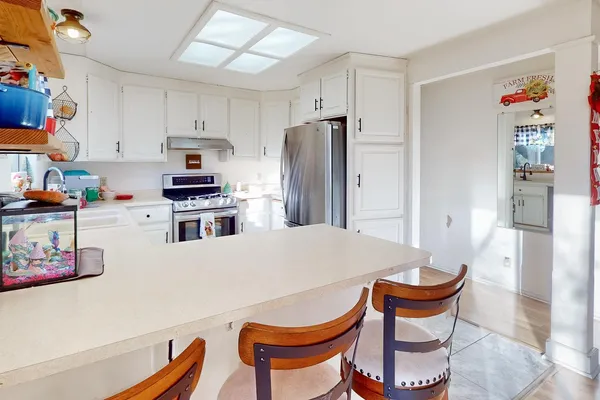 a kitchen with stainless steel appliances a stove a refrigerator and a dining table