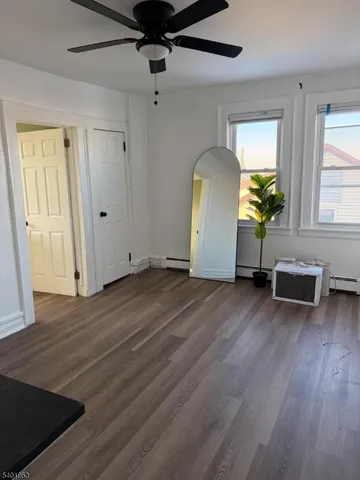 a view of a livingroom with wooden floor and a ceiling fan