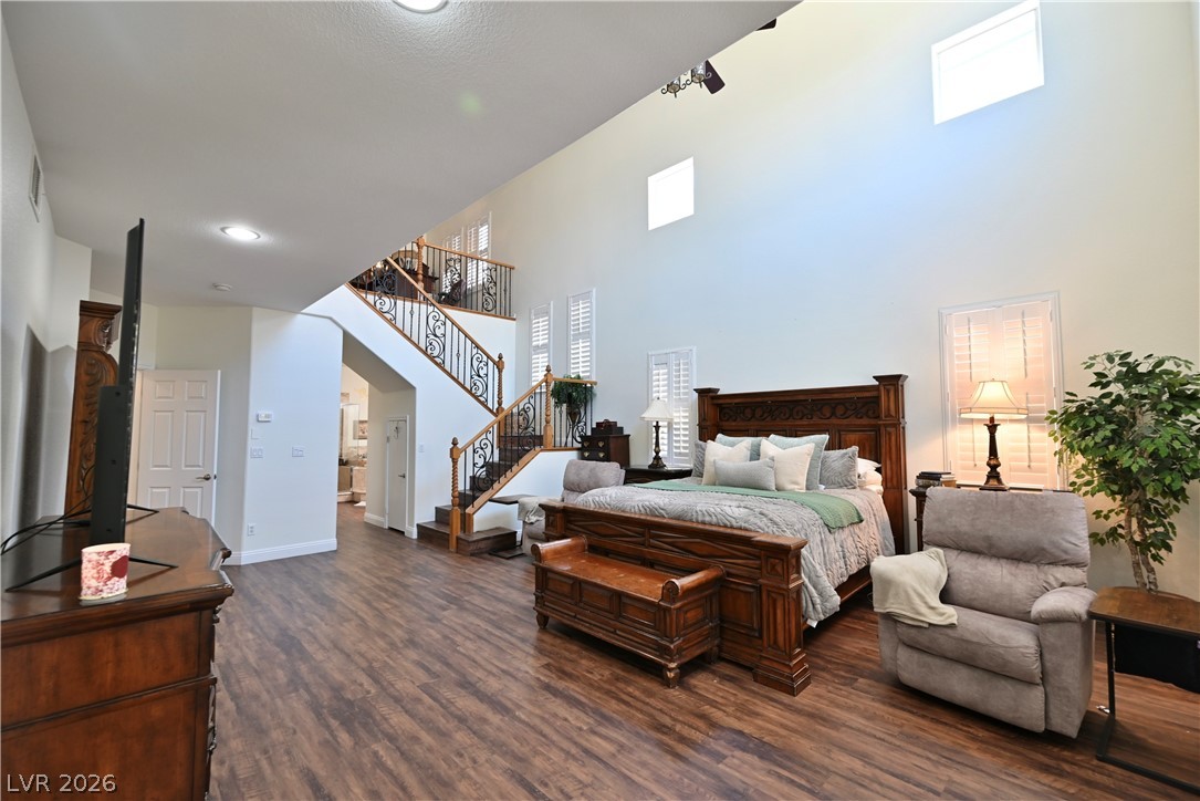 2729 Kildrummie Street Henderson, NV 89044 - Photo 5 of 42 Rich hardwood floors complement the spacious primary bedroom with a grand staircase leading to the upper level.