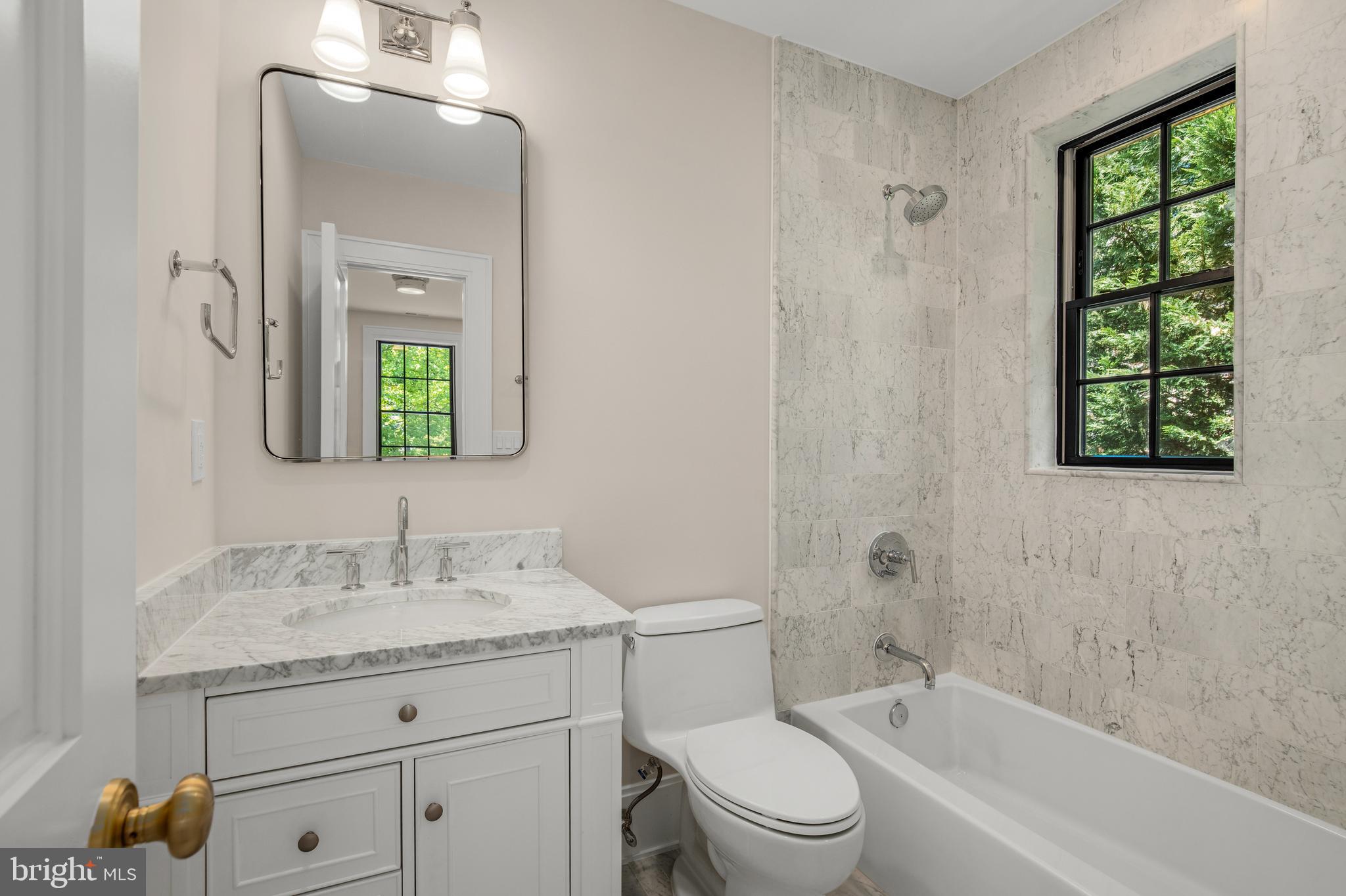 2710 36th Street Northwest Washington, DC 20007 - Photo 21 of 29 a bathroom with a toilet a sink a tub and a window