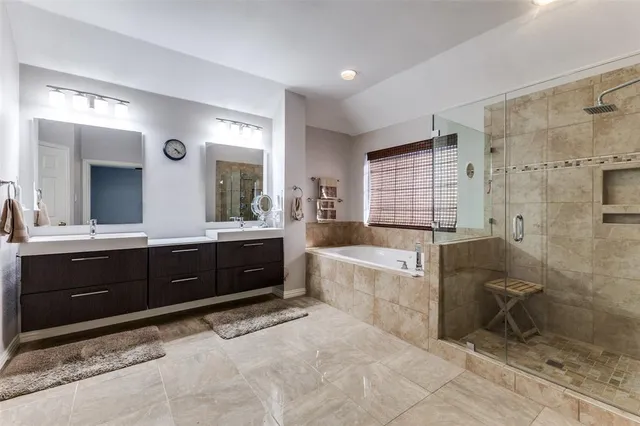 a spacious bathroom with a granite countertop tub sink shower and mirror