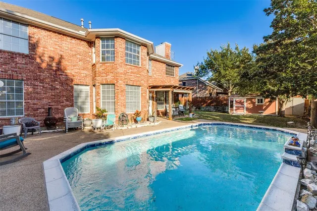 a view of a house with pool and sitting area