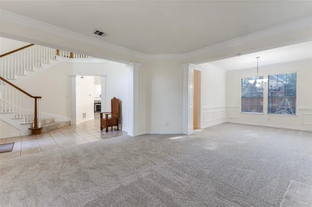 a view of empty room with stairs and a window