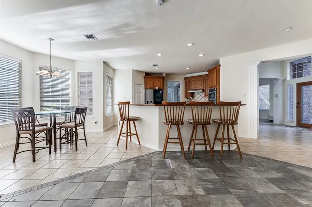 a open kitchen with stainless steel appliances granite countertop dining table chairs and granite counter tops
