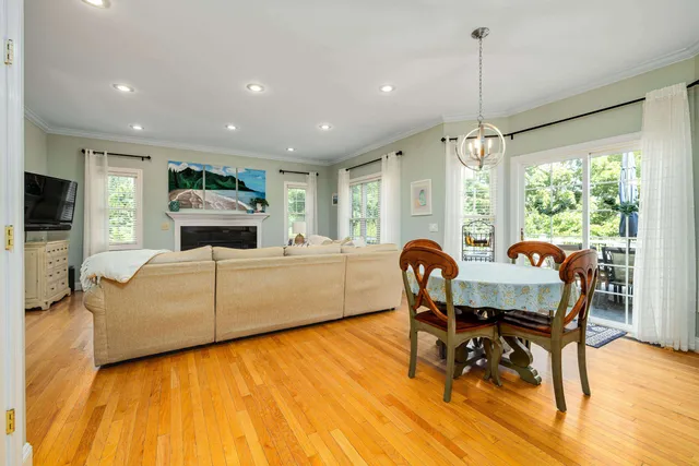 a view of a dining room with furniture a chandelier and wooden floor