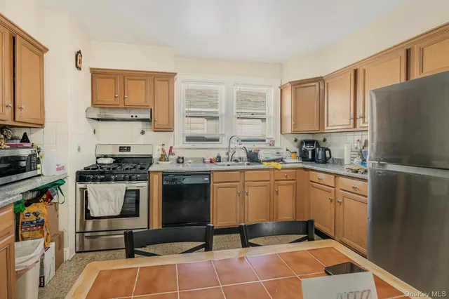 a kitchen with granite countertop a sink stainless steel appliances and cabinets