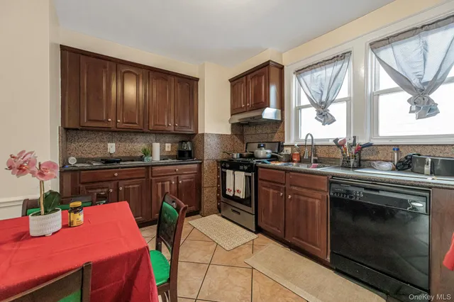 a kitchen with stainless steel appliances granite countertop a stove top oven a sink dishwasher and cabinets