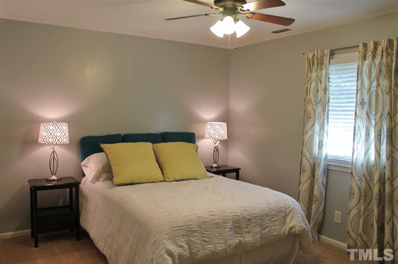 4004 Grimstead Lane Raleigh, NC 27613 - Photo 13 of 25 a bedroom with a bed and a chandelier