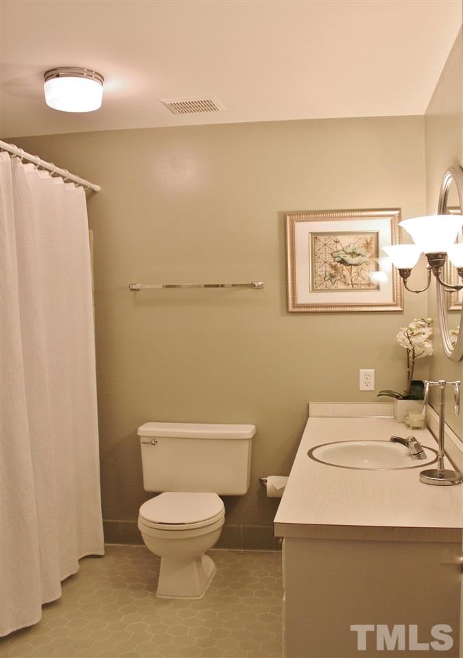 4004 Grimstead Lane Raleigh, NC 27613 - Photo 19 of 25 a bathroom with a sink a toilet and a mirror