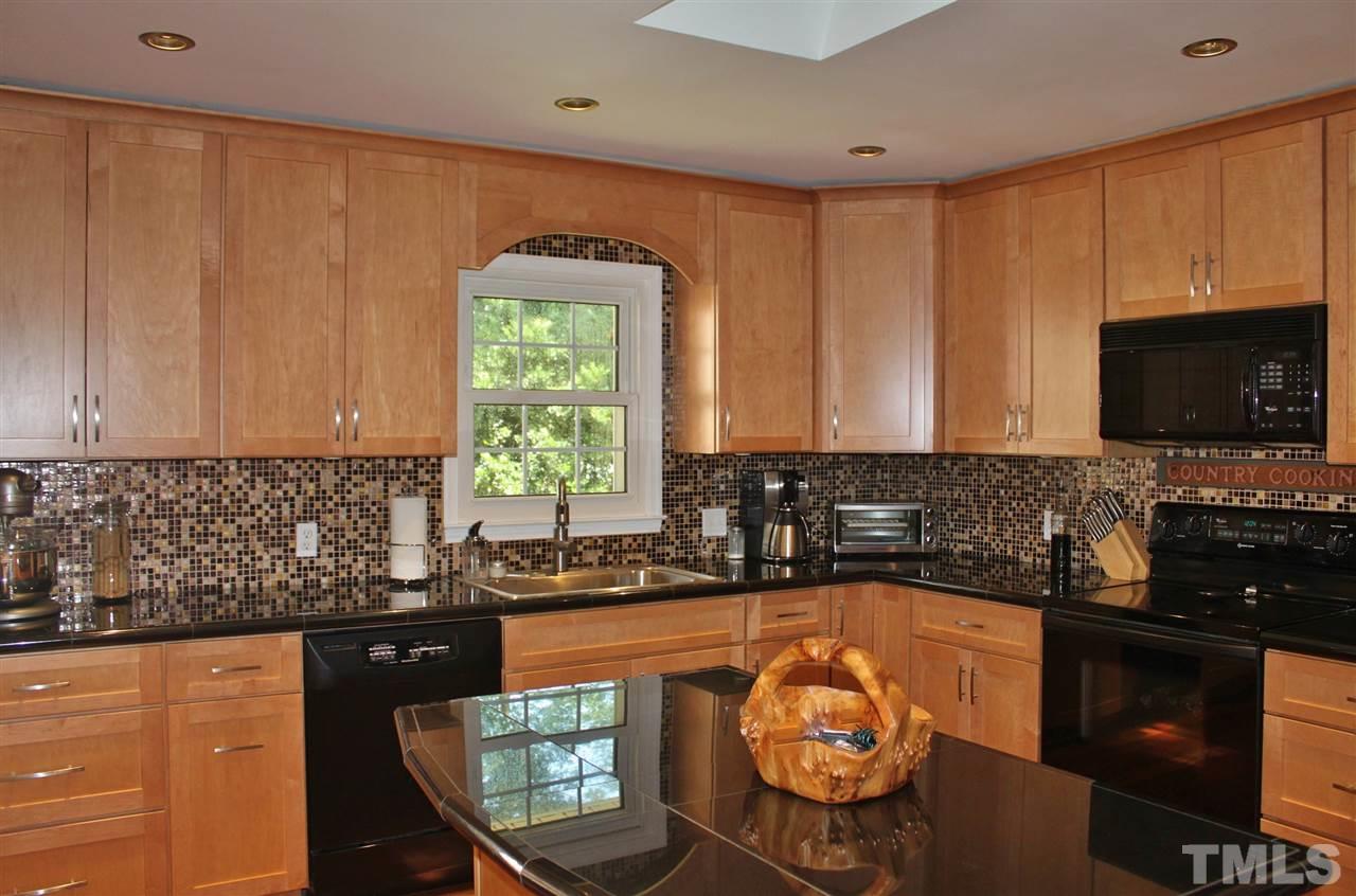 4004 Grimstead Lane Raleigh, NC 27613 - Photo 3 of 25 a kitchen with a sink a stove and cabinets