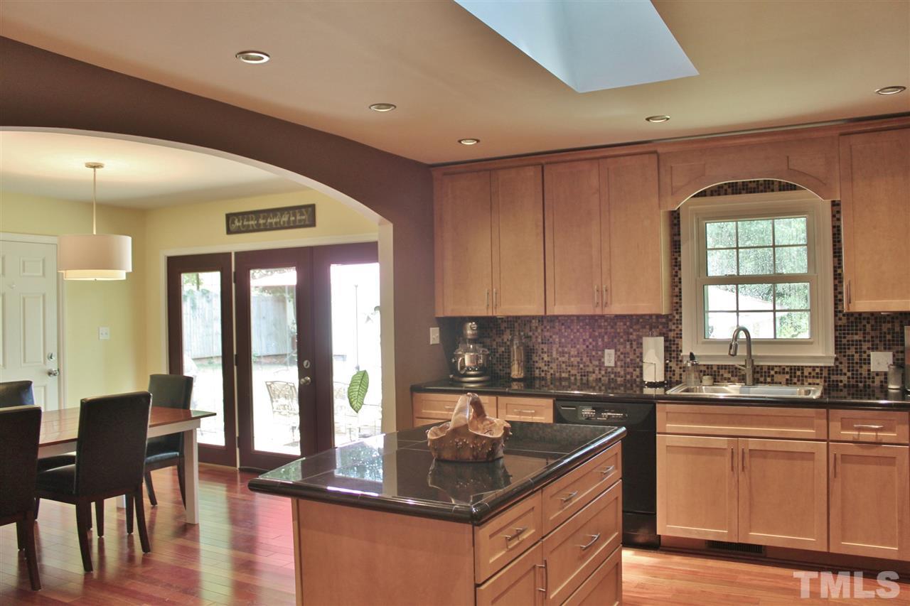 4004 Grimstead Lane Raleigh, NC 27613 - Photo 4 of 25 a kitchen with granite countertop a stove a sink and a granite counter top